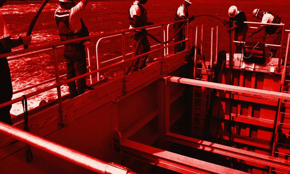 Cuadrilla con EPP manejando mangueras de descarga de una bomba